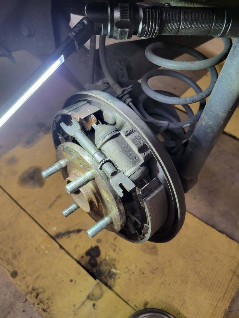Brake assembly on a car lifted in the New Level Auto Service shop