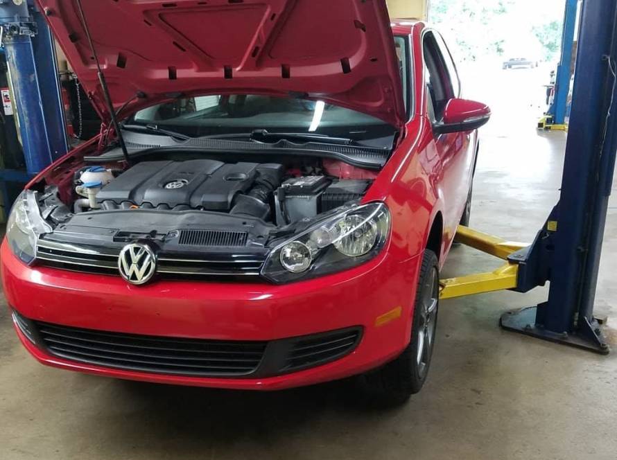 Car on a lift with the hood open at New Level Auto Service in Rockville, MD